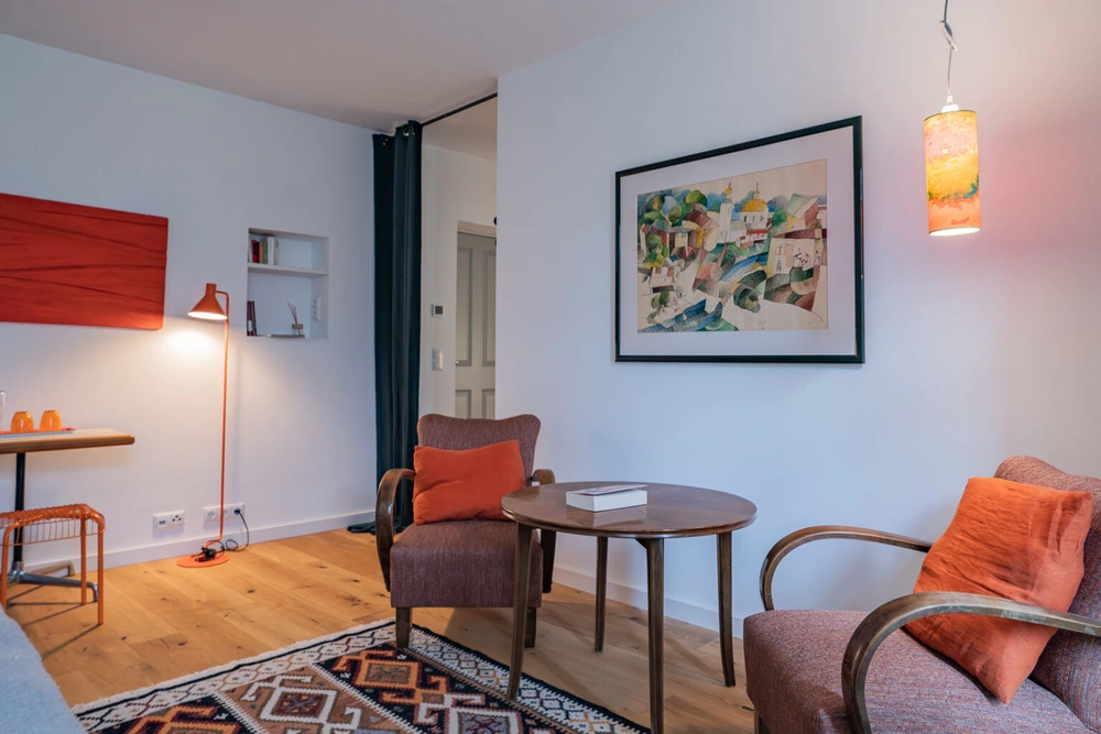 Ein modernes Zimmer, ausgestattet mit bequemen Sitzmöglichkeiten. Es ist alles sehr modern gestaltet.