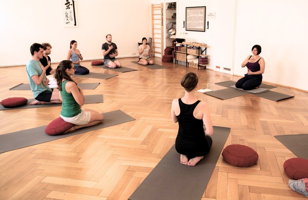 Die Yogis sitzen im Kreis um Manuela und richten ihren Fokus nach innen