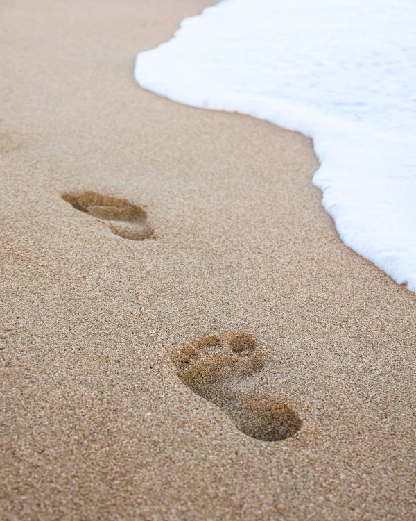Fußspuren im Sand umspült vom Meer