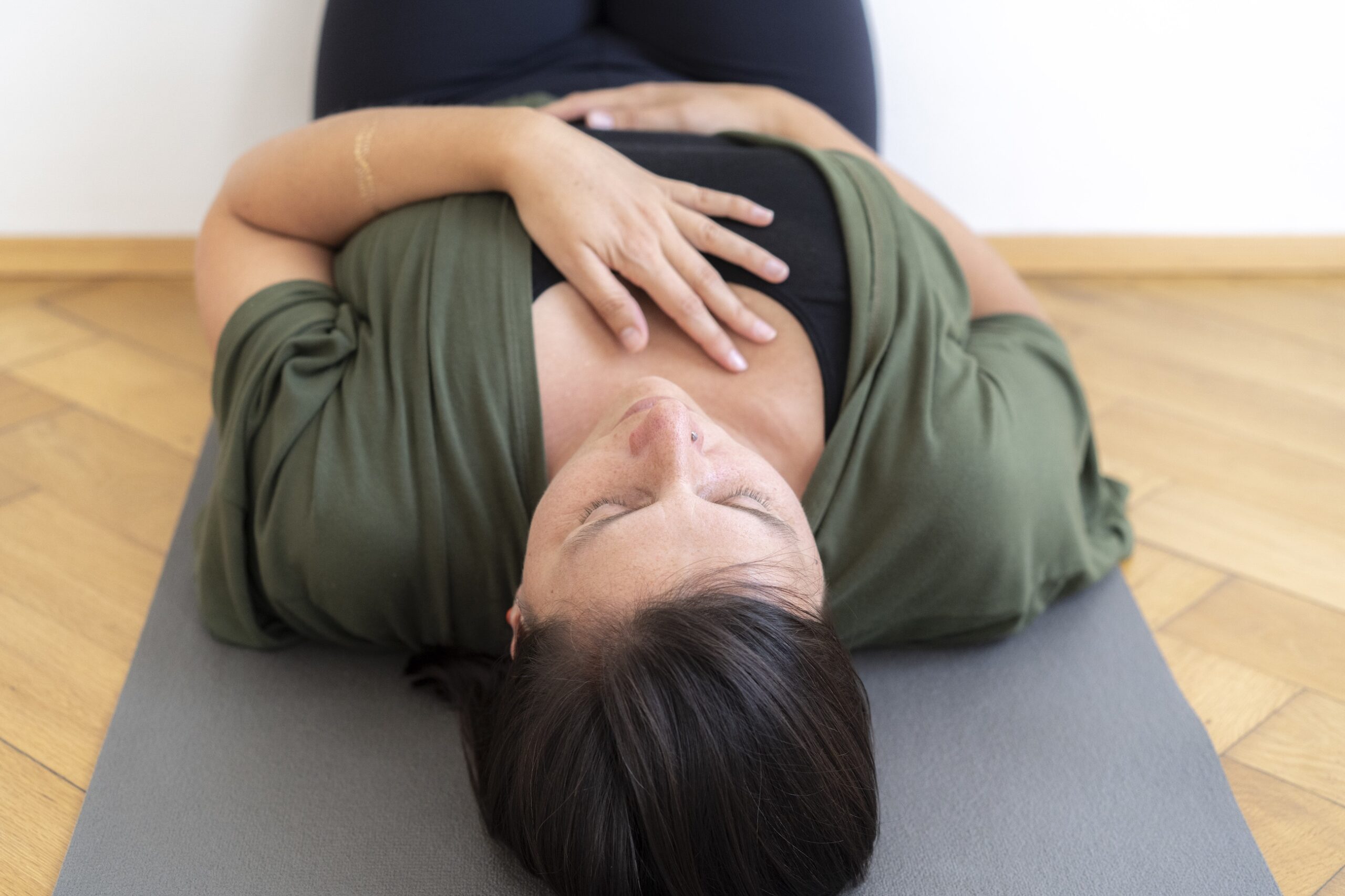 Mayogi-yin yoga pose mit Hand auf dem Herzen